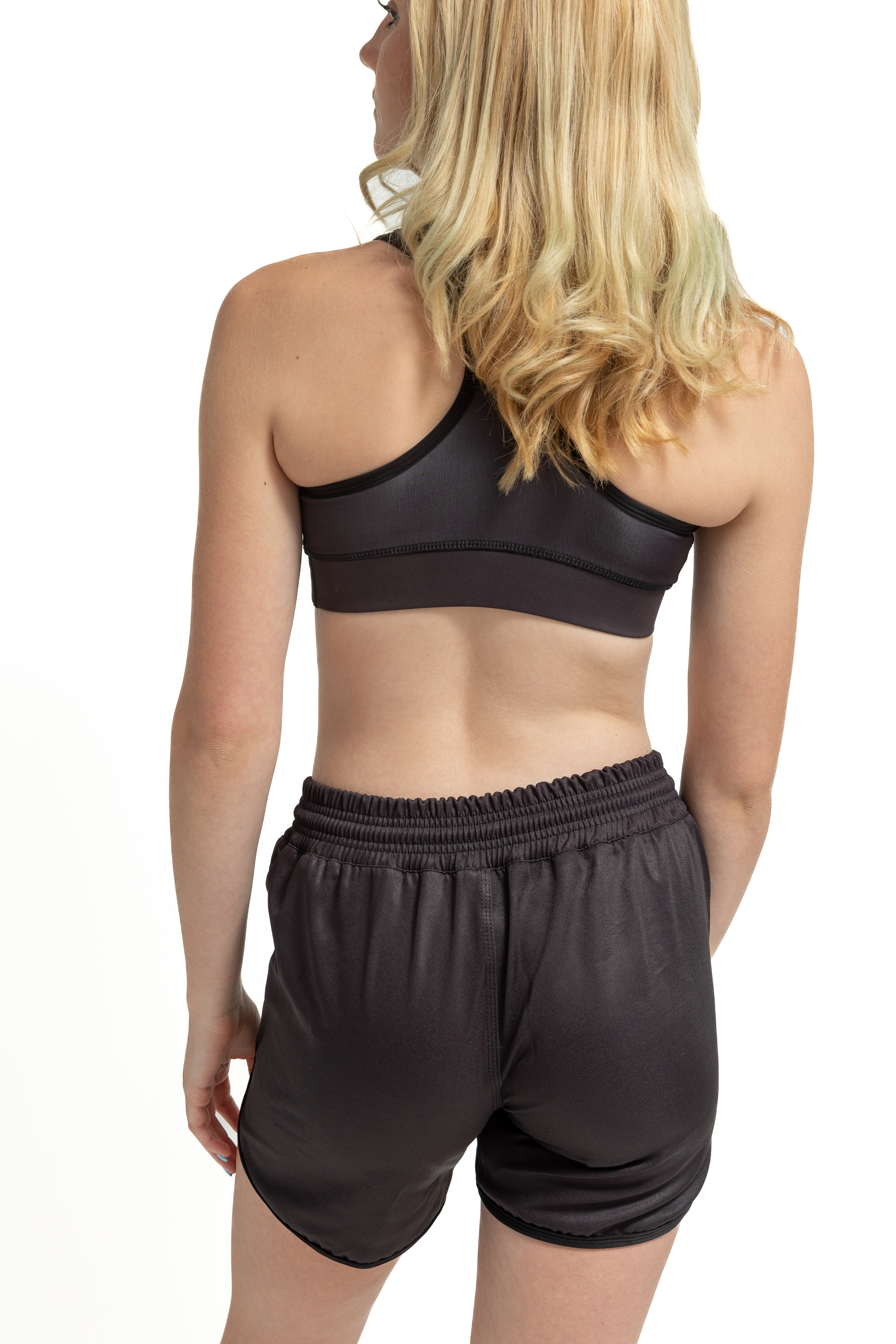 Girl modeling high-compression sports bra and black athletic shorts